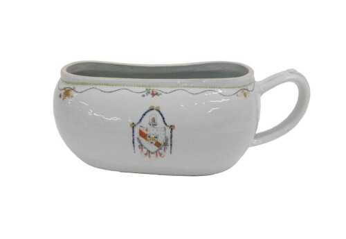 An 18thC Chinese armorial porcelain bourdaloue, with moulded handle and slipper shaped body,...