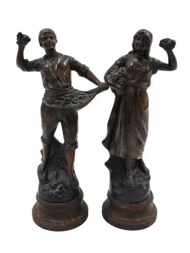 A pair of 20thC spelter figures of a lady and gentleman, each holding flowers, on an inverted...