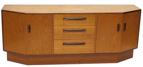 A 1960s teak sideboard, of shaped rectangular form, centred by three drawers, and four cupboards,...