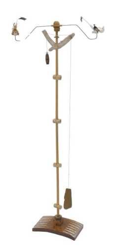 An unusual 20thC child's mobile, with cylindrical beech stem set with seated figures, with pull...