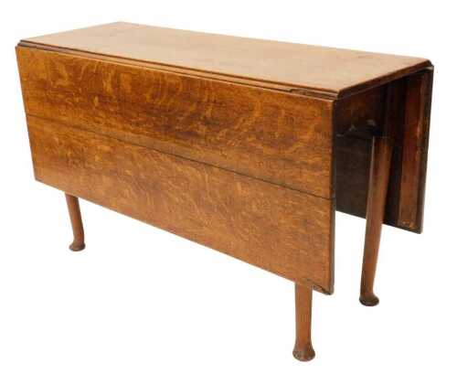 An early 19thC oak drop leaf table, of rectangular form, plain cylindrical legs terminating in...