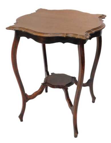 An Edwardian mahogany window table, the carved top raised on sabre legs joined by an under tier,...
