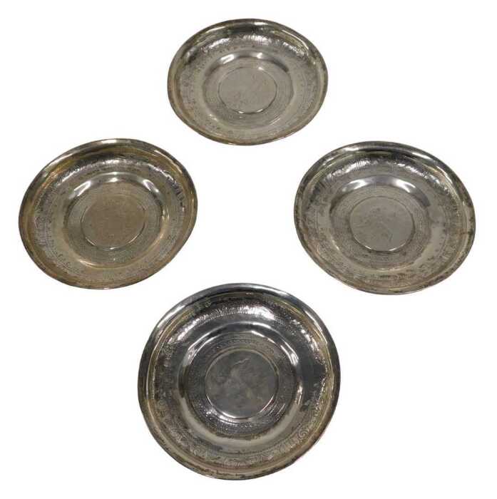 Four silver dishes, inset with European coins, to include Theresa style, unmarked white metal,...
