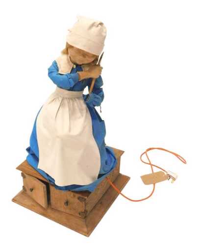 An unusual 20thC maid automaton, formed as a girl in floral robes holding spoon, with electrical...
