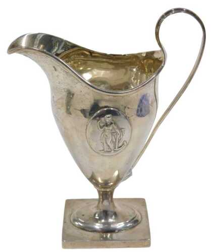 An Edward VII silver cream jug, with strap handle, helmet shaped body, inverted stem and oval...