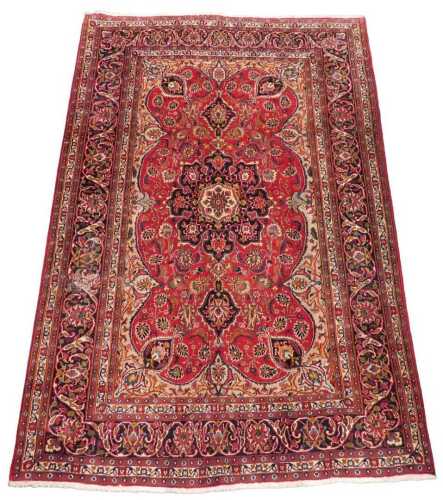 A 20thC Persian Kashan style rug, predominantly in red and blue, the outer field with a repeat...