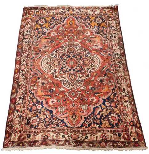 A 20thC Persian style woollen rug, predominantly in blue, red and cream, the outer field with a...