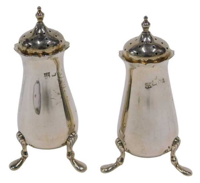 A pair of Edward VII silver pepper pots, each with urn finials, pierced domed removable lids,...