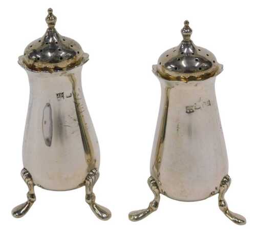 A pair of Edward VII silver pepper pots, each with urn finials, pierced domed removable lids,...