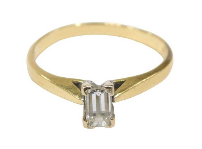 An 18ct gold diamond solitaire ring, set with baguette cut diamond, 5.2mm x 3.2mm x 2.8mm,...