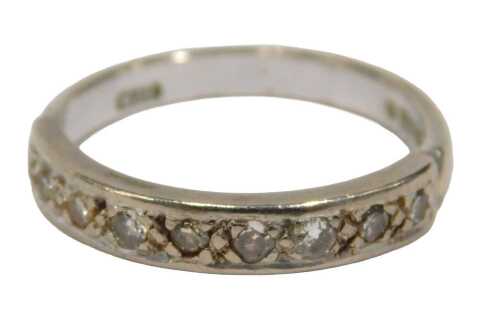 A 15ct white gold diamond half hoop dress ring, set with nine round brilliant cut diamonds, each...