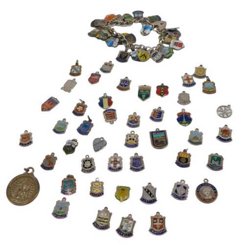 A silver charm bracelet and group of assorted silver and enamel souvenir crest charms, some...