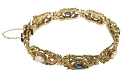 A 9ct gold opal and spinel bracelet, each link of cross over and scroll design, centred by an...