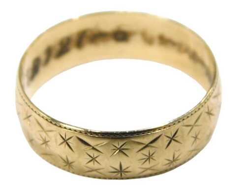 A 9ct gold wedding band, of dot and star etched decoration, 5mm band, London 1960, ring size O&frac12;,...