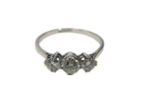 A three stone diamond dress ring, set with three round brilliant cut diamonds, the centre stone...