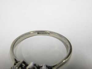 A three stone diamond dress ring, set with three round brilliant cut diamonds, the centre stone... - 2