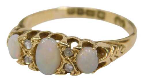 An 18ct gold opal and diamond gypsy ring, set with three oval cut opals, and four tiny diamonds,...