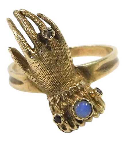 A Georgian style 9ct gold glove tanned ring, the cuffed collar set with cabochon, opal and ruby,...