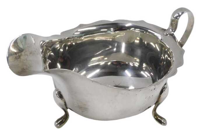 An Elizabeth II silver sauce boat, with flared rim, ear shaped handle, on triple hoof feet, by...