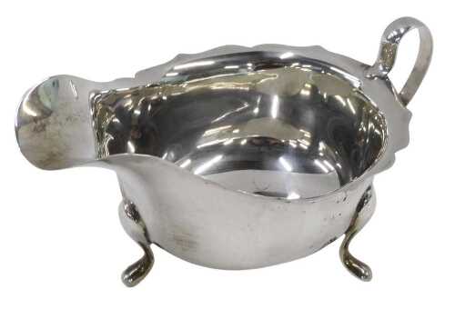 An Elizabeth II silver sauce boat, with flared rim, ear shaped handle, on triple hoof feet, by...