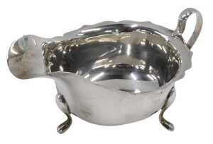 An Elizabeth II silver sauce boat, with flared rim, ear shaped handle, on triple hoof feet, by...