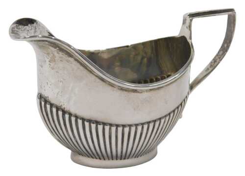 An Edward VII silver cream jug, of small proportion, with shaped spout, strapwork handle, part...
