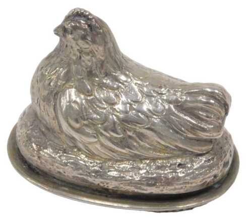 A Continental miniature hen model ornament, with a hinged lid revealing a shallow plain interior,...