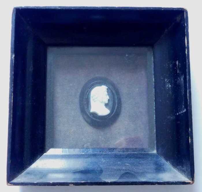 A 19thC carved ivory miniature portrait of a Renaissance gentleman in profile, on ebonised oval...