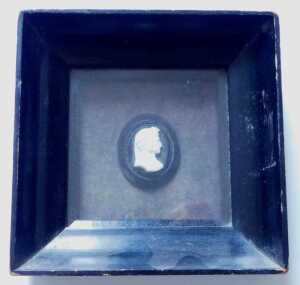 A 19thC carved ivory miniature portrait of a Renaissance gentleman in profile, on ebonised oval...