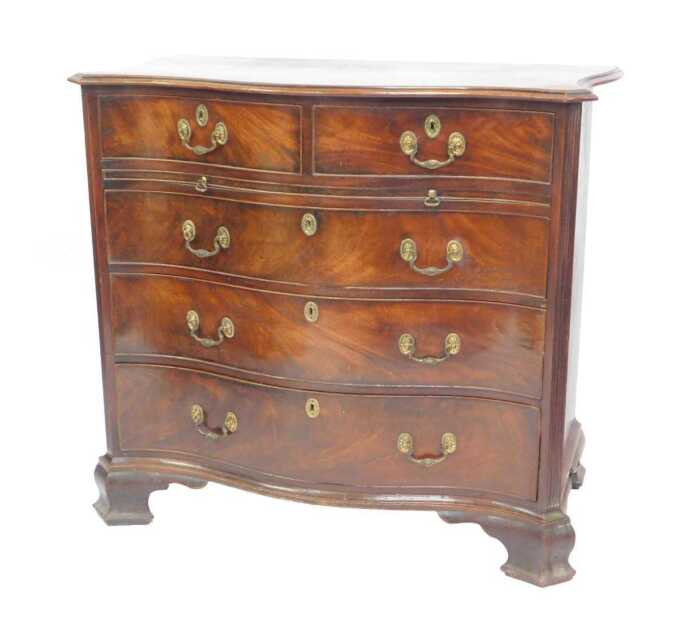 A George III mahogany serpentine bachelor's chest, with moulded top over two drawers, over...