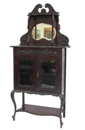 A late Victorian mahogany display cabinet, the scrolling leaf-carved top above a moulded shaped...