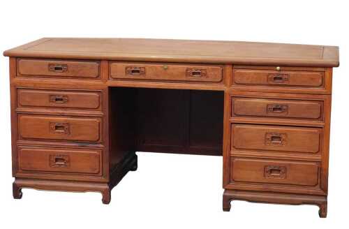 A 20thC Chinese cherrywood pedestal desk, the rectangular top with a canted back, with an...