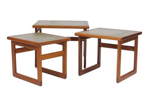 A 1970s teak nest of three tables, each with a green tiled top, raised on U shaped supports, the...