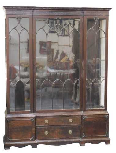 A Chippendale style mahogany inverted breakfront display cabinet, the top with a dentil-moulded...