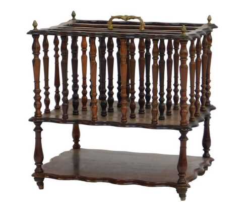 A Victorian mahogany Canterbury, the waved top surmounted by a brass handle and brass finials,...