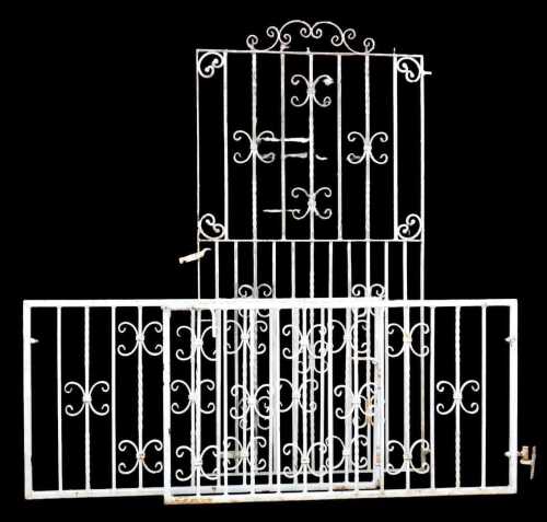 A white painted wrought iron garden gate, decorated with scrolling motifs, 182cm high, 95cm wide,...