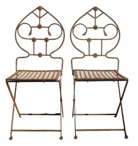 A pair of wrought metal folding garden chairs, each with a spade top, lattice-work seats, on...