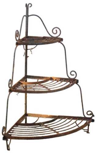 A wrought metal three tier corner plant stand, with scrolling end supports, partially black...