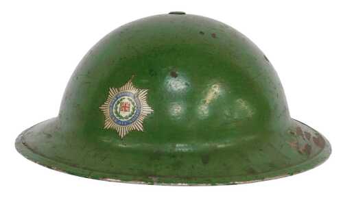 A World War II British Army combat helmet, painted green, with black leather liner, fabric chin...