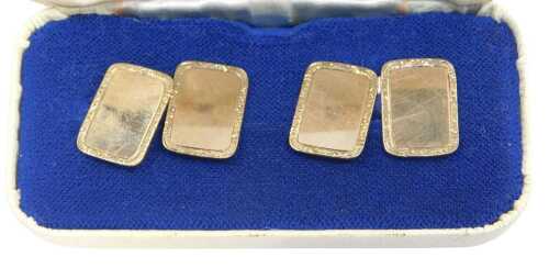 A pair of Elizabeth II 9ct gold rectangular cufflinks, each with an engine-turned border and...
