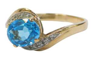 A 9ct gold QVC dress ring, centred with an oval cut aquamarine, and cz set shoulders, on a...