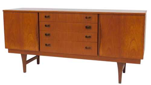 A 1970s teak sideboard, with four central graduated drawers flanked by two cupboards, raised on...