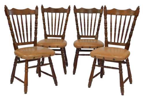 A set of four Dutch oak dining chairs, each with a spindle turned back and a pale brown leather...
