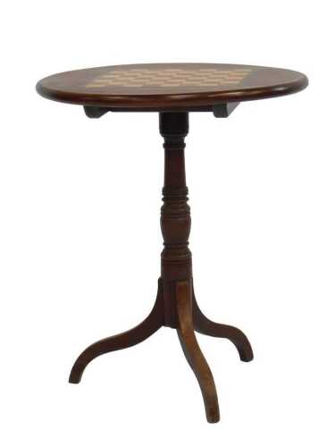 A mahogany tilt top games table, the circular top inlaid with a parquetry chess board, on a...