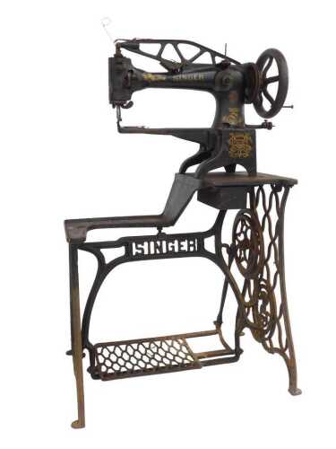 A Singer cobbler's sewing machine, with gilt decoration to the black paint, on a treadle base...