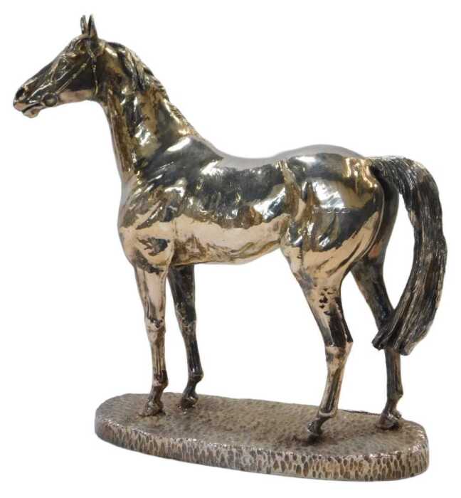 An Elizabeth II loaded silver model of a horse, wearing a bridle and bit, mounted on a...