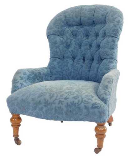 A Victorian button back armchair, upholstered with blue fabric, on turned tapering legs with...