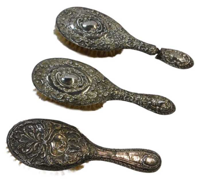 Two Edward VII silver mounted hairbrushes, repousse decorated with flowers and scrolls,...