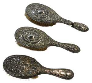 Two Edward VII silver mounted hairbrushes, repousse decorated with flowers and scrolls,...