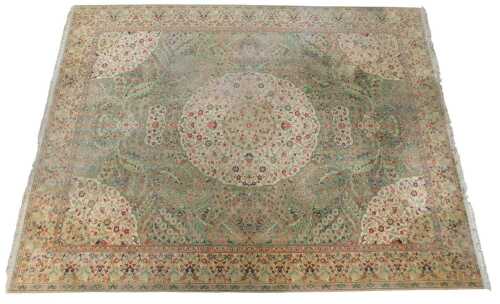 A machine woven carpet in Oriental style, with a central medallion, in cream, on a leaf and...